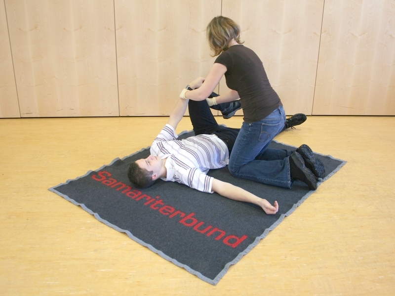 abgewandtes Knie fassen, Handgelenk des abgewandten Arm des Patienten wird an Knie angelegt