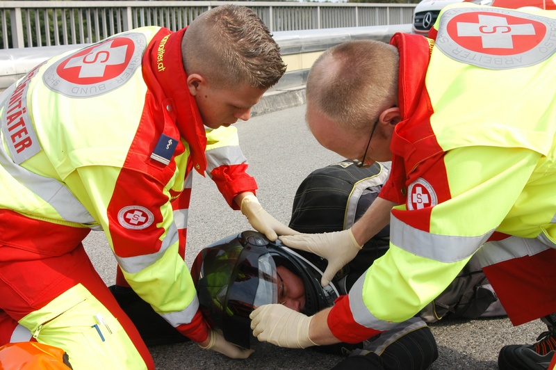 Den Kopf sofort mit den Händen fixieren, Visier öffnen und Patienten ansprechen.