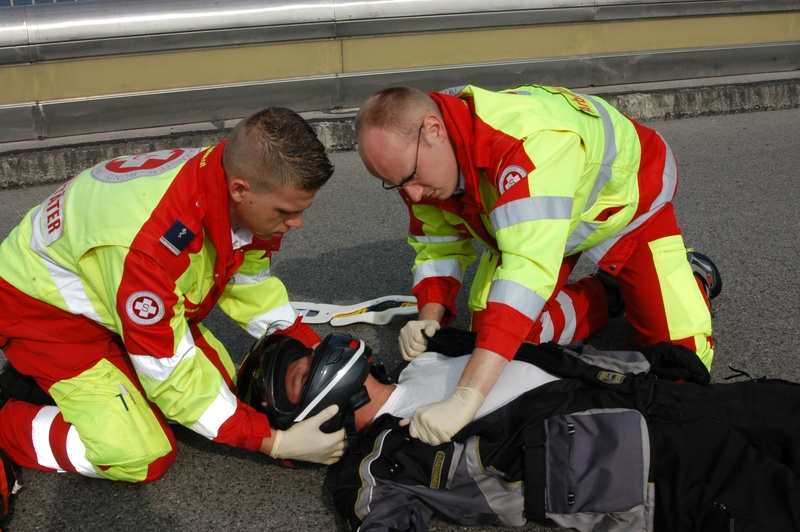 Ggfs. Brille entfernen, Kinnriemen öffnen und behindernde Kleidung entfernen.