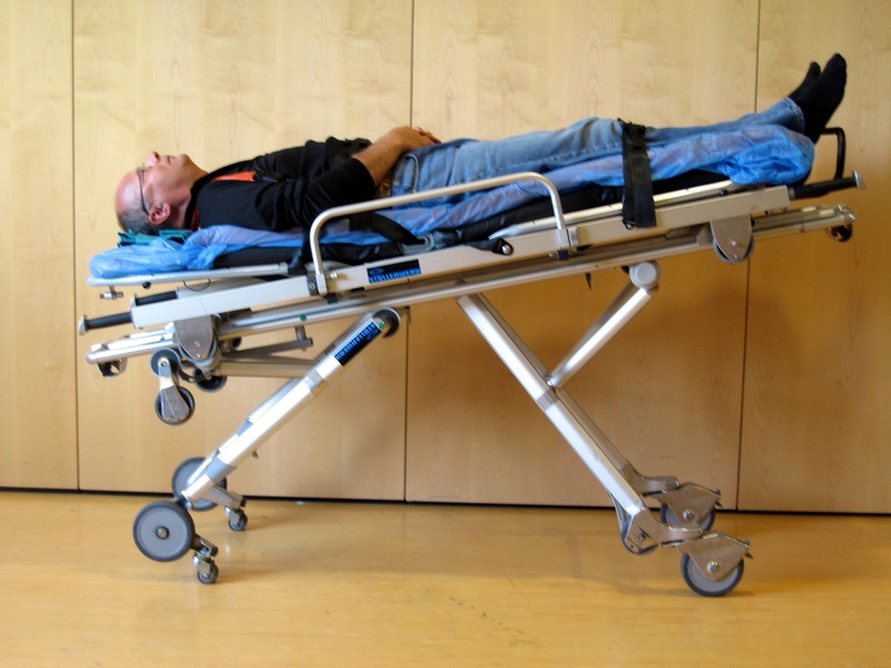 Lagerung mit erhöhten Beinen unter Schonung der Wirbelsäule und des Beckens (bei Verdacht auf Wirbelsäulen- oder Beckenverletzungen)